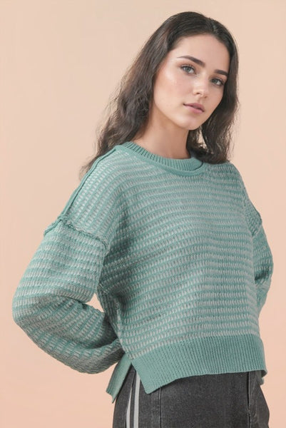 Woman wearing a green sweater against a beige background