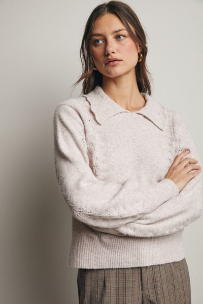 Woman wearing a light pink sweater with a neutral background