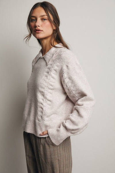 Woman wearing a light pink knitted cardigan against a plain background
