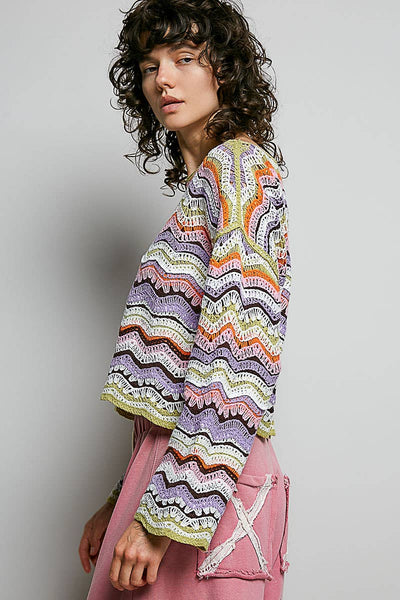 Woman wearing a colorful patterned top against a plain background