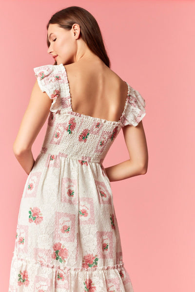 Woman wearing a floral dress against a pink background