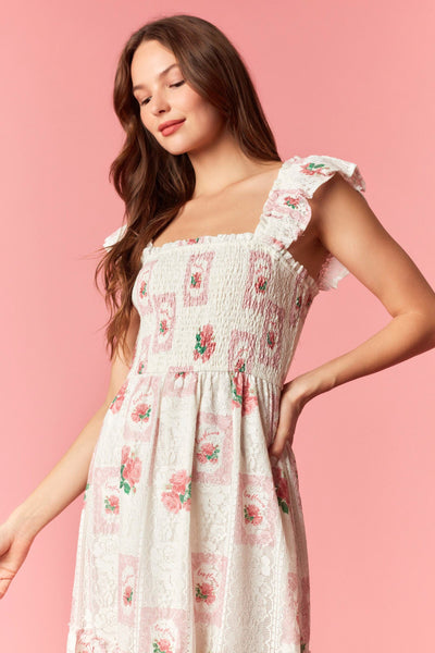 Woman wearing a floral dress against a pink background