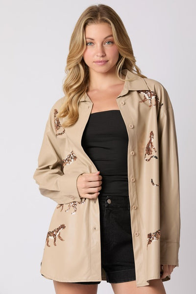 Woman wearing a beige trench coat with floral embroidery on a white background