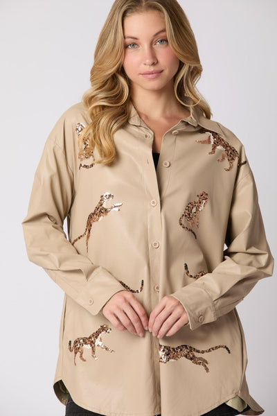 Woman wearing a beige shirt with leopard embroidery on a white background