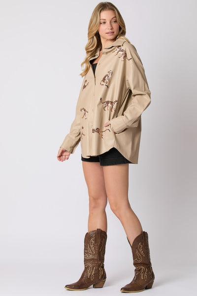 Woman wearing a beige jacket with patterns and brown cowboy boots on a white background