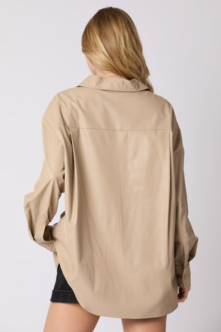 Person wearing a beige shirt on a plain background