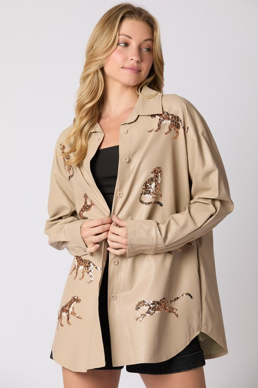 Woman wearing a beige jacket with embroidered designs on a white background