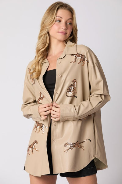 Woman wearing a beige jacket with embroidered designs on a white background
