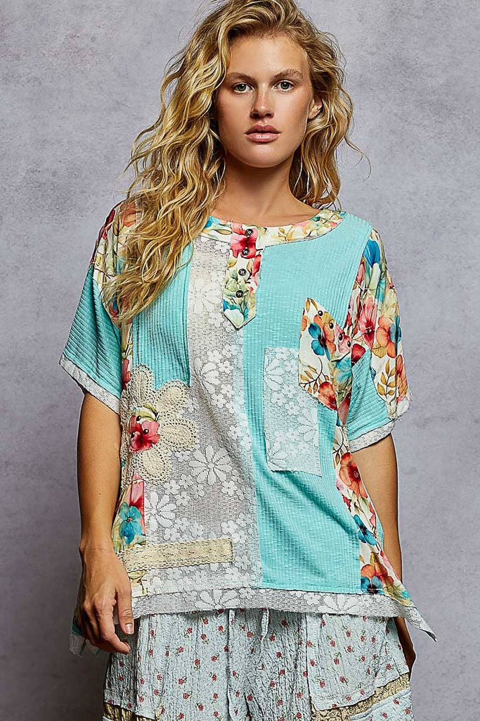 Woman wearing a colorful floral top against a gray background
