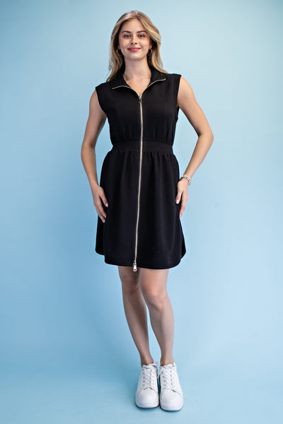 Woman wearing a black sleeveless dress with a zipper on a light blue background