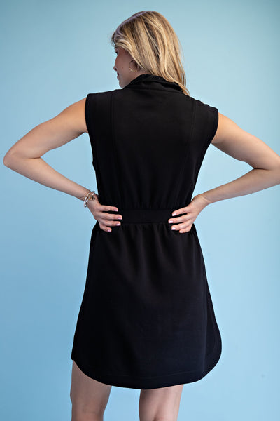 Woman wearing a black sleeveless dress against a light blue background
